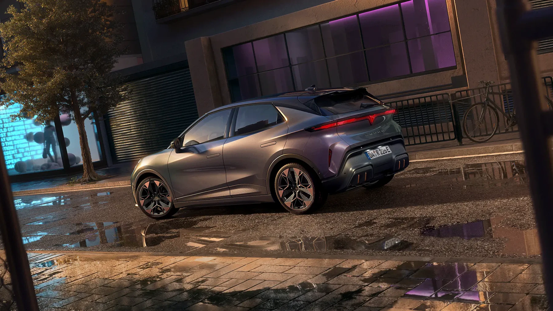 CUPRA Raval von schraeg hinten mit markanten LED-Rueckleuchten, sportlichem Diffusor mit kupferfarbenen Akzenten und charakteristischen Leichtmetallfelgen.