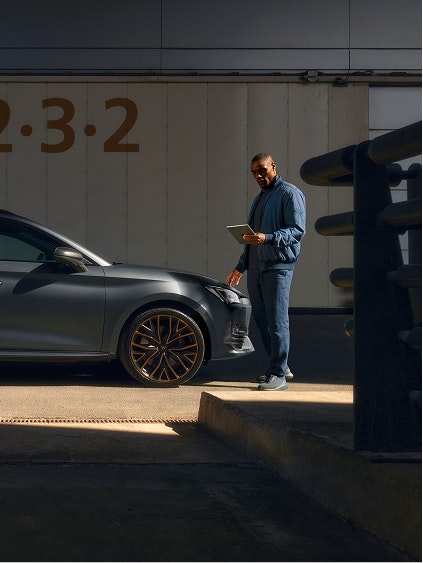 CUPRA Leon Sportstourer als Approved Gebrauchtwagen, sportliche Seitenansicht im Außenbereich mit Prüfer