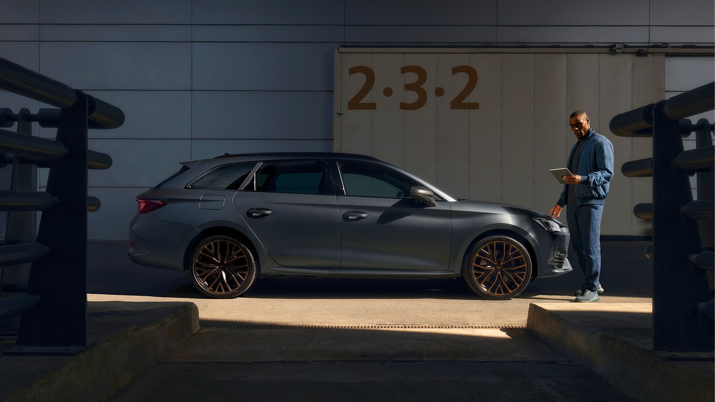 CUPRA Leon Sportstourer als Approved Gebrauchtwagen, sportliche Seitenansicht im Außenbereich mit Prüfer