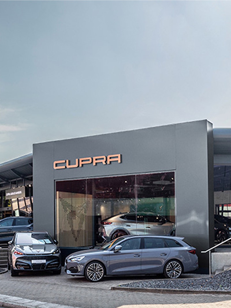 Außenansicht der CUPRA Garage Hamburg mit zwei ausgestellten CUPRA Fahrzeugen vor dem Eingang