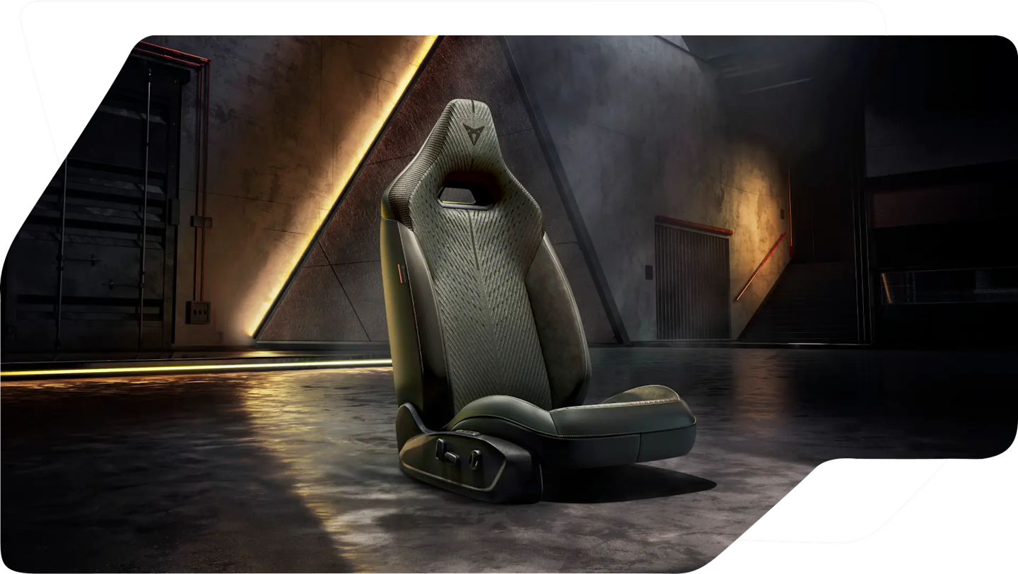 CUPRA Performance-Sitz freigestellt in einer dunklen Industriekulisse mit warmen Lichtreflexen auf dem Boden